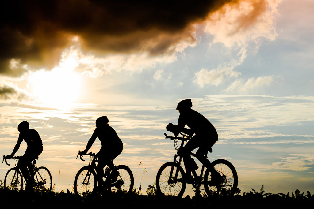 Grupo de ciclistas entrenando al atardecer en una carretera